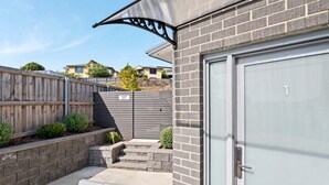 Un garage residenziale con porta in metallo, parete in mattoni e recinzione in legno.