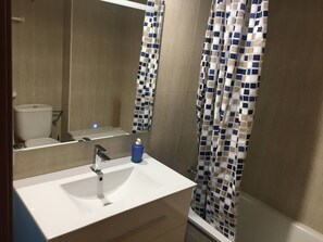 Een haardroger, handdoeken, zeep, toiletpapier