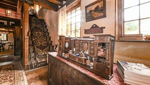 A traditional room with a wooden chest of drawers, a patterned rug, and a large window with a view of greenery. - Hell Fyre 1594 by inspirestays.com - a cottage that sleeps 2 guests in 1 bedroom (Itchingfield, nr Horsham)