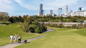 A golf course with a city skyline in the background.