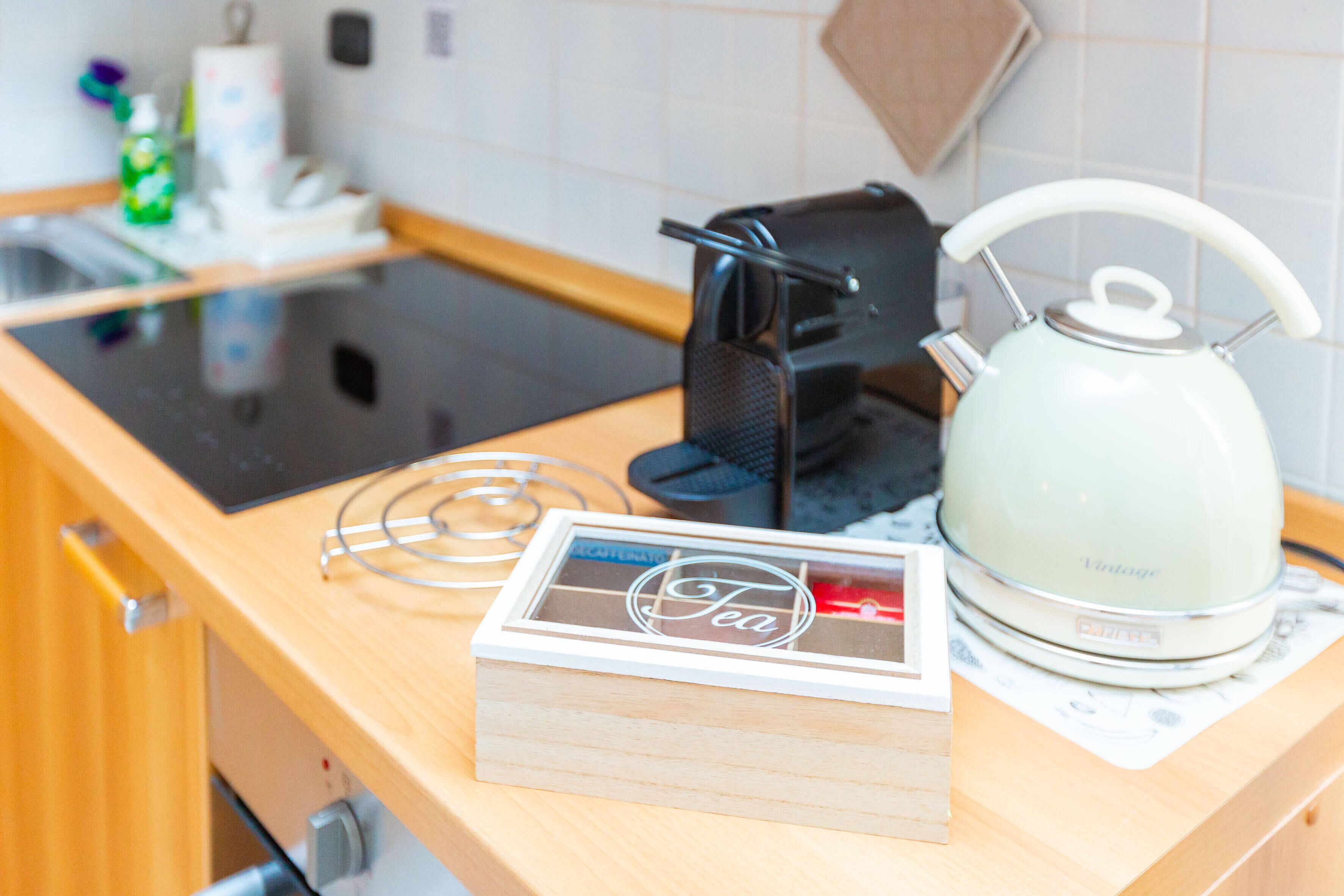 Un comptoir de cuisine avec une boîte à thé, une bouilloire et une machine à café.