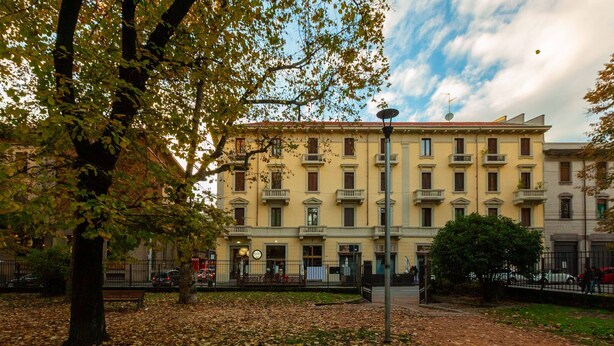 A building with multiple windows and balconies, surrounded by trees and a grassy area. - HAPPY HOUSE [7 minutes from MXP and 30 minutes from Milan] (Busto Arsizio)
