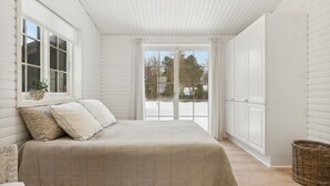 A bedroom with a large bed, a window, and a view of the outside.