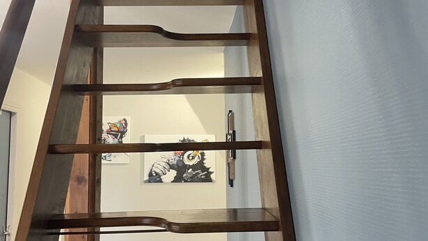 Een houten trap met meerdere treden die uitkomt op een plateau.