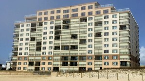 A multi-story hotel with balconies and a beach view. - This two-bedroom, two bathroom condo has a beautiful view of the ocean, and outdoor pool. (Ocean City)