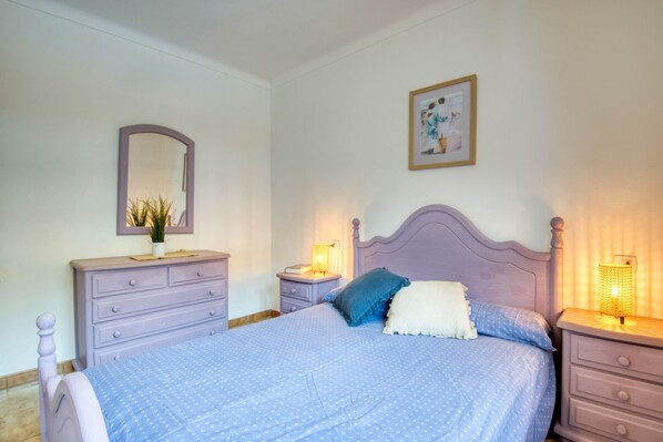 A bedroom with a bed, dresser, nightstands, and a mirror. - TREBOL: Apartment in l'Escala with community pool and garden, ideal for families (L'Escala)