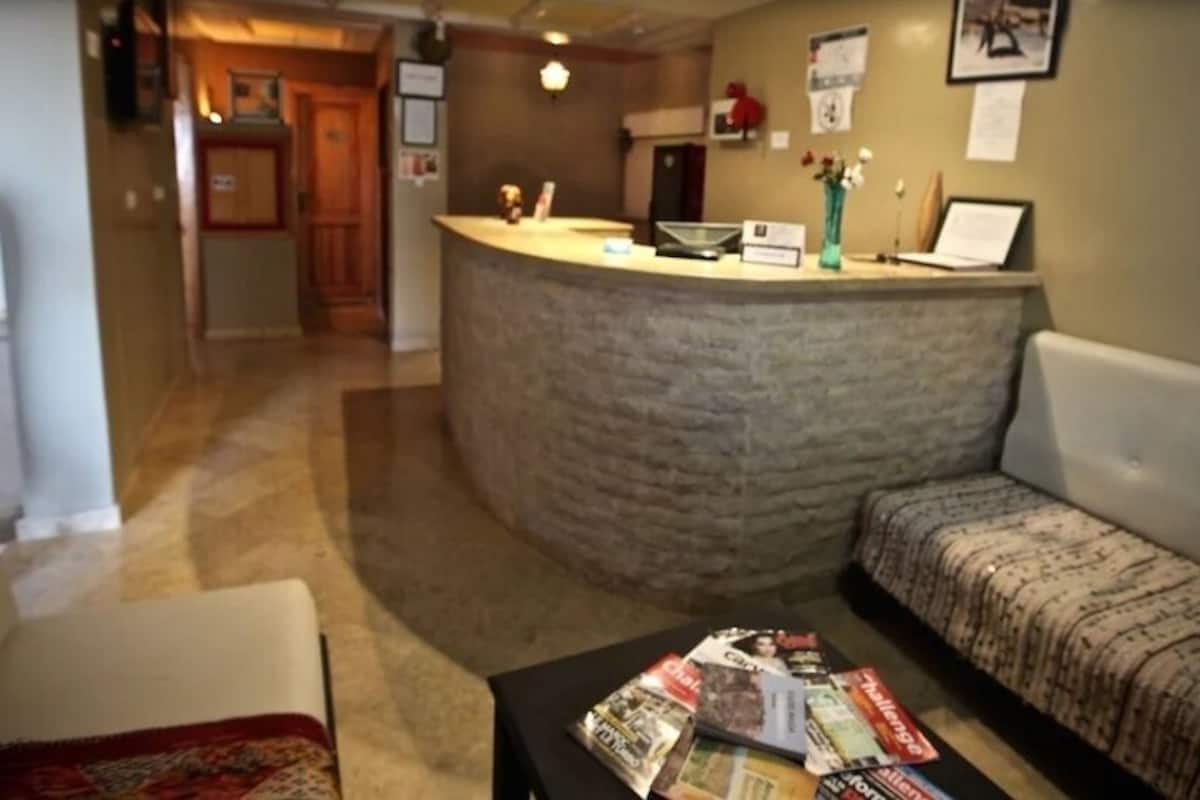 A reception area with a curved counter, a sofa, and a coffee table with magazines.