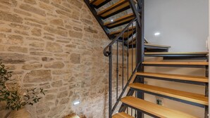 A staircase with wooden steps and metal railings, leading to an upper floor.