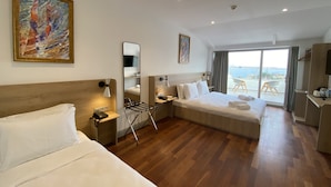 A hotel room with two beds, a large window with a view, a painting on the wall, and a balcony with outdoor furniture. - Joyway Hotels Istanbul Sultanahmet (Istanbul)