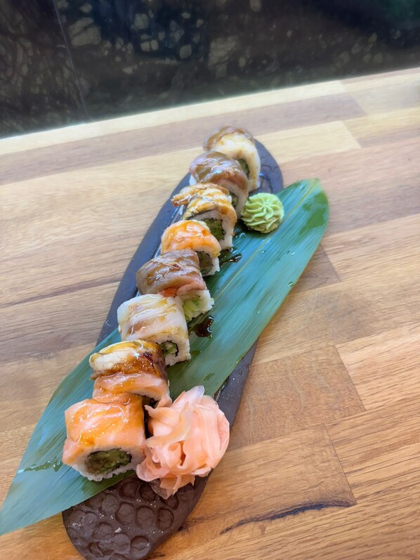 Un plateau de sushis sur une table en bois.