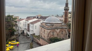 A view of a historic building with a dome and a minaret, overlooking a street with parked yellow taxis and pedestrians. - Joyway Hotels Istanbul Sultanahmet (Istanbul)
