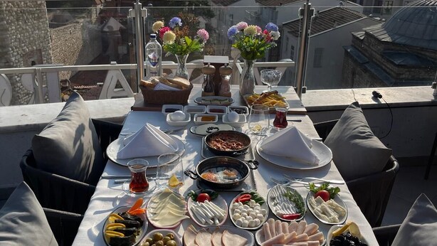 A table set with a variety of dishes and drinks, overlooking a body of water with a distant ship. - Joyway Hotels Istanbul Sultanahmet (Istanbul)
