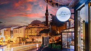 A hotel with a prominent sign, a historic building in the background, and a street with moving lights. - Joyway Hotels Istanbul Sultanahmet (Istanbul)