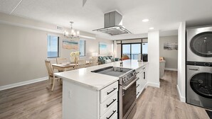 Una cocina moderna con una isla central, horno empotrado y electrodomésticos de acero inoxidable.