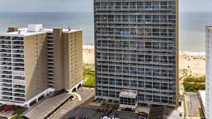 A high-rise hotel with multiple floors, a beach view, and a parking area. - Century I Condo with Ocean Views & Outdoor Pool! (Ocean City)