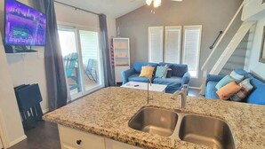 A kitchen with granite countertops, a double sink, and a built-in TV. - Bay Sunset Views - Waterfront Pool - Boat Slip (Port Isabel)