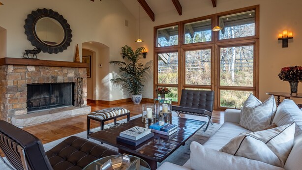 Un salón espacioso con chimenea, ventanas amplias y una zona de estar acogedora.