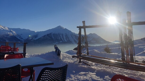 Een besneeerd berglandschap met een skilift en gondels.