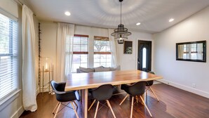 A dining area with a wooden table, black chairs, and a pendant light. - 5 Mi to Dtwn Austin: Vibrant Home w/ Patio (Austin)