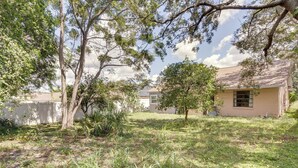 A residential property with a house, a fenced yard, and mature trees. - Orlando Home: 6 Mi to Universal! (Orlando)