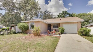 A single-story house with a garage, a front lawn, and a driveway. - Orlando Home: 6 Mi to Universal! (Orlando)