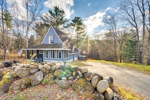 A house with a stone wall in front, surrounded by trees and a clear sky. - Cozy Bethlehem Family Cabin Near Skiing & Hiking! (Bethlehem)