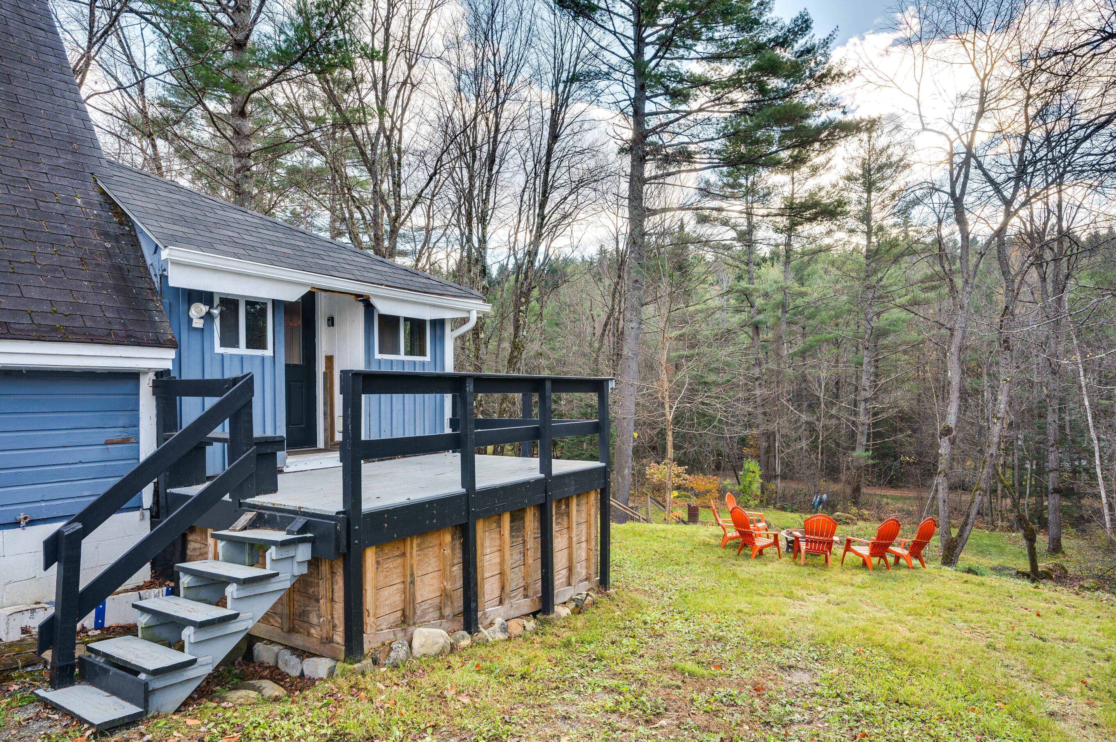 A cabin with a wooden deck and outdoor seating area.