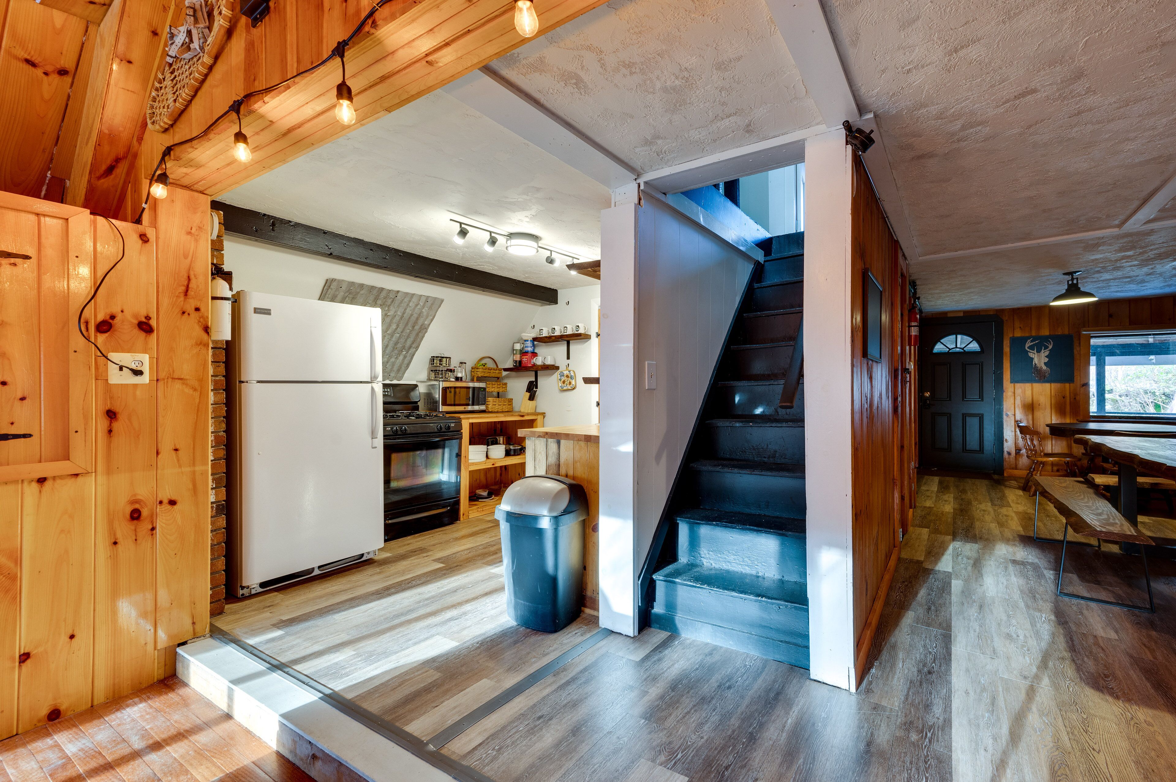 Un interior de madera con cocina, comedor y escalera.