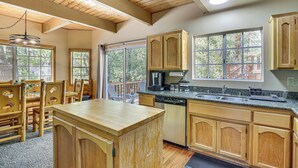 A kitchen with wooden cabinets, a granite countertop, and a built-in dishwasher.