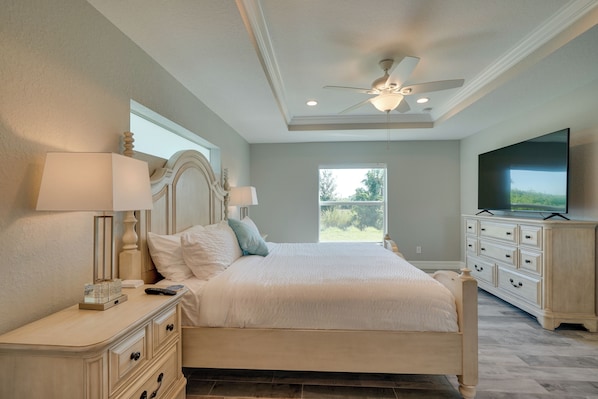 A bedroom with a bed, nightstands, a dresser, a television, and a ceiling fan. - South Gulf Cove Port Charlotte Retreat: Gas Grill (Port Charlotte)