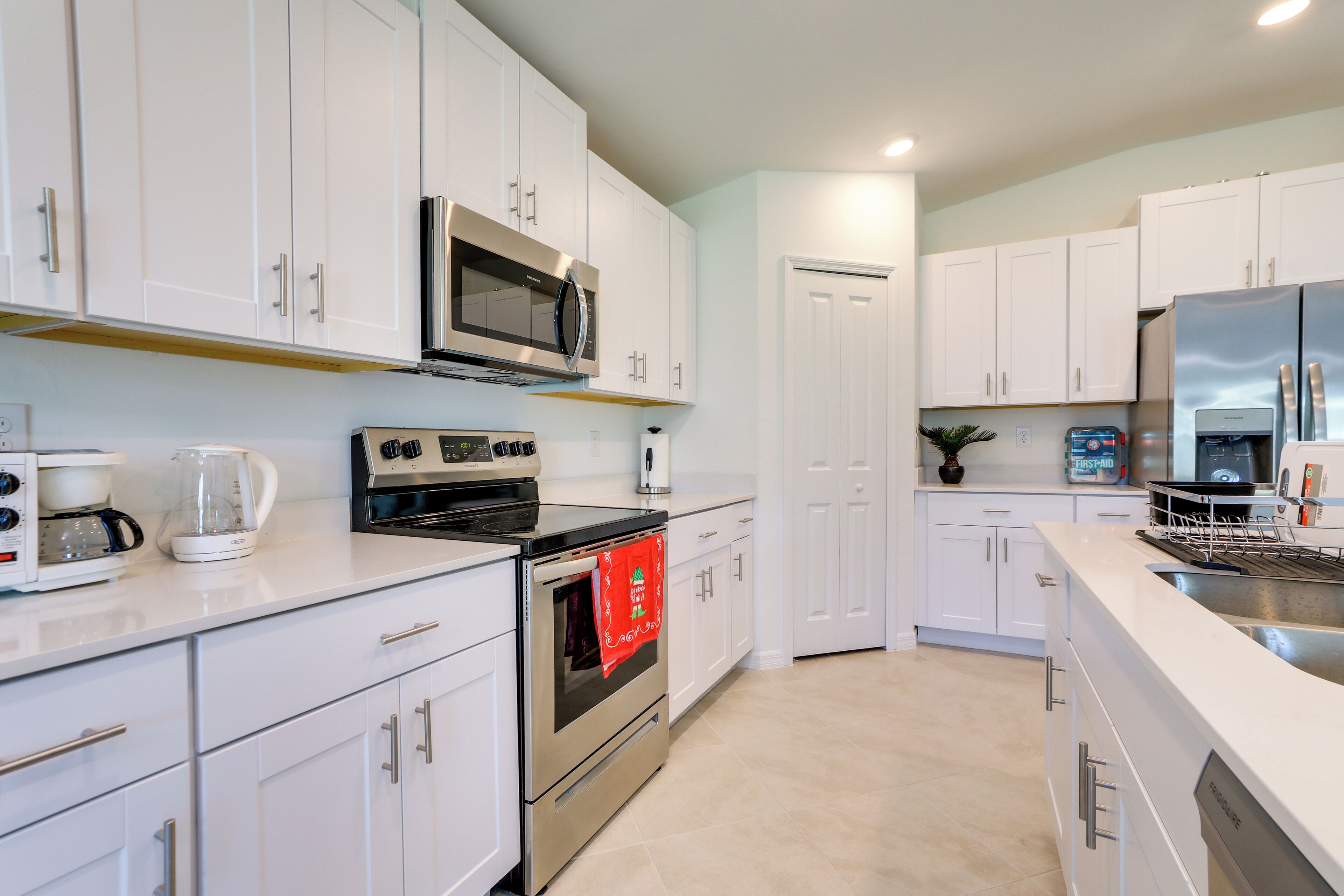 A modern kitchen with white cabinets, stainless steel appliances, and a built-in oven.