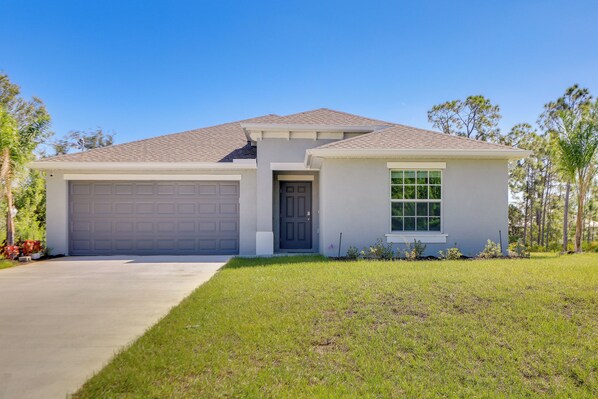 A single-story house with a garage, a front door, and a window.