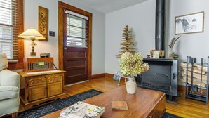 A cozy living room with a wooden coffee table, a vintage radio, a fireplace, and a bookshelf. - Pet-friendly Topton Home w/ Patio, Deck & Views! (Topton)