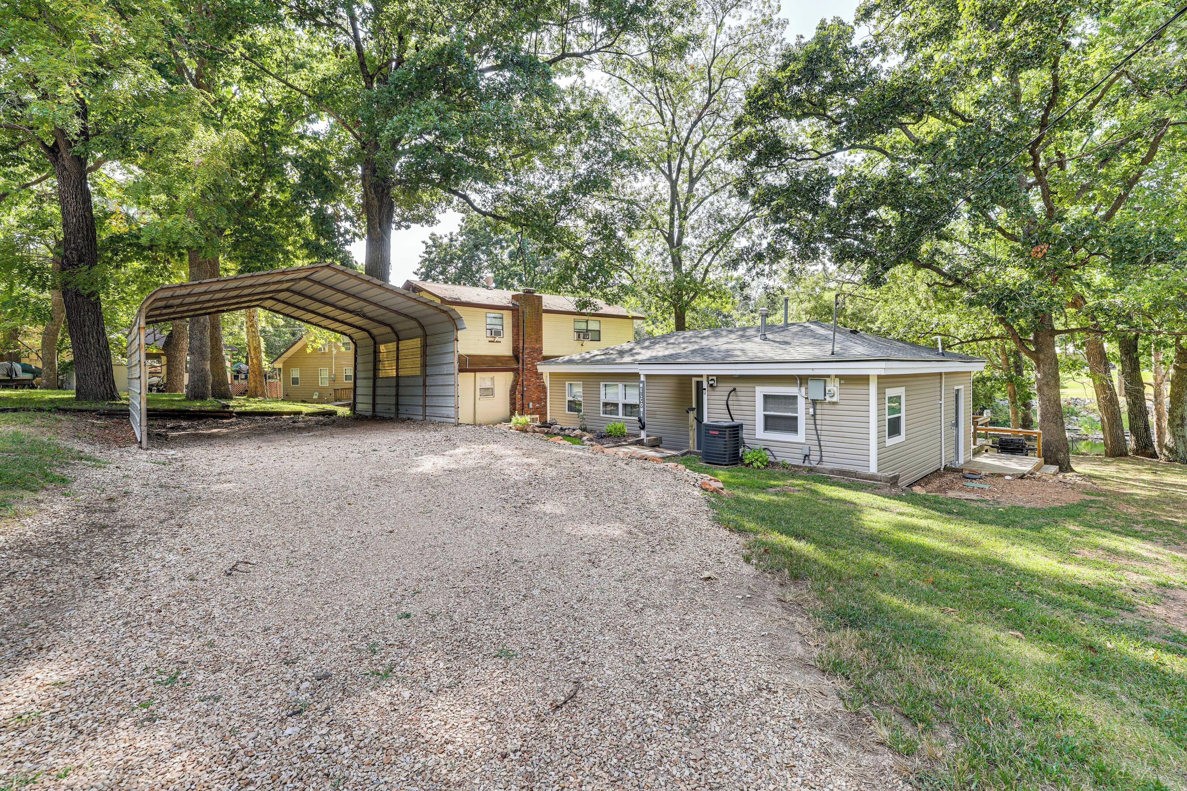 A house with a gravel driveway, a covered porch, and a small shed.