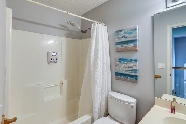 A bathroom with a shower, toilet, and a sink.