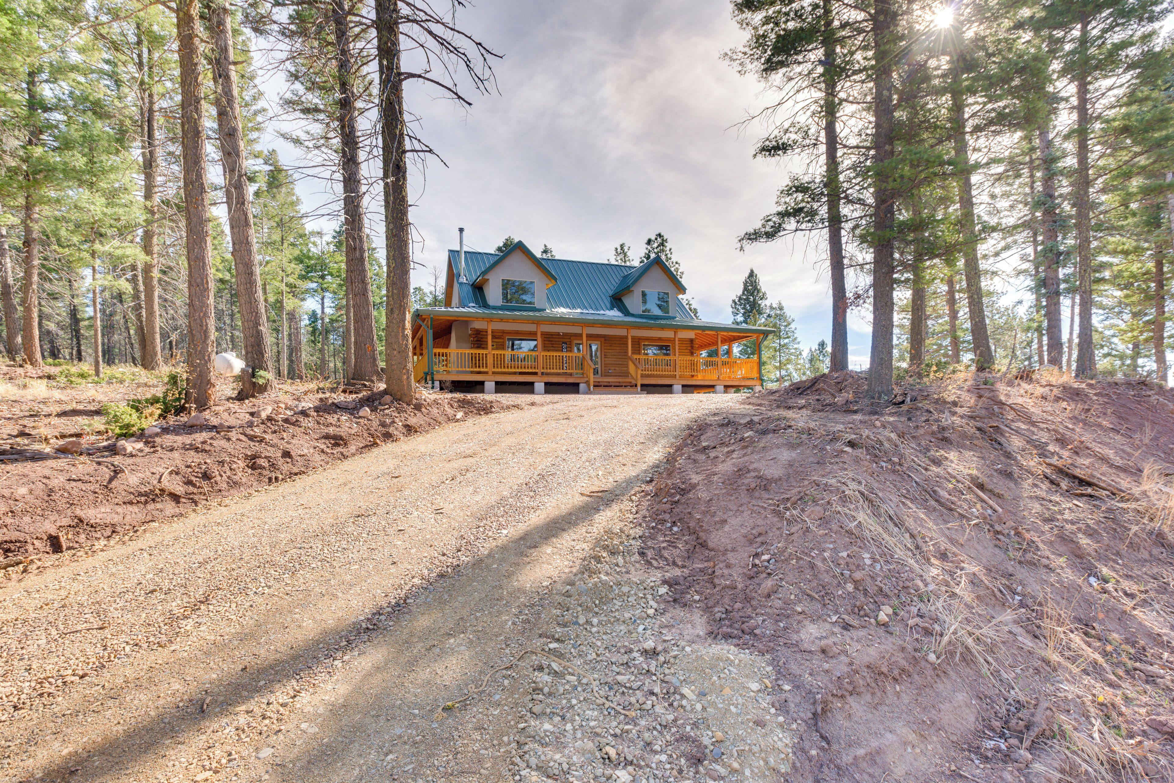 A cabin with a porch, surrounded by a forest.