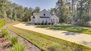A two-story house with a front yard, driveway, and surrounding trees. - Family-friendly Crawfordville Home ~ 15 Mi to Fsu! (Crawfordville)
