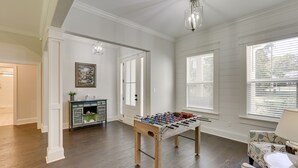 A room with a wooden foosball table, a sofa, and a cabinet with decorative items. - Family-friendly Crawfordville Home ~ 15 Mi to Fsu! (Crawfordville)