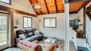 Una sala de estar acogedora con un sofá de cuero, una mesita de centro y una chimenea.