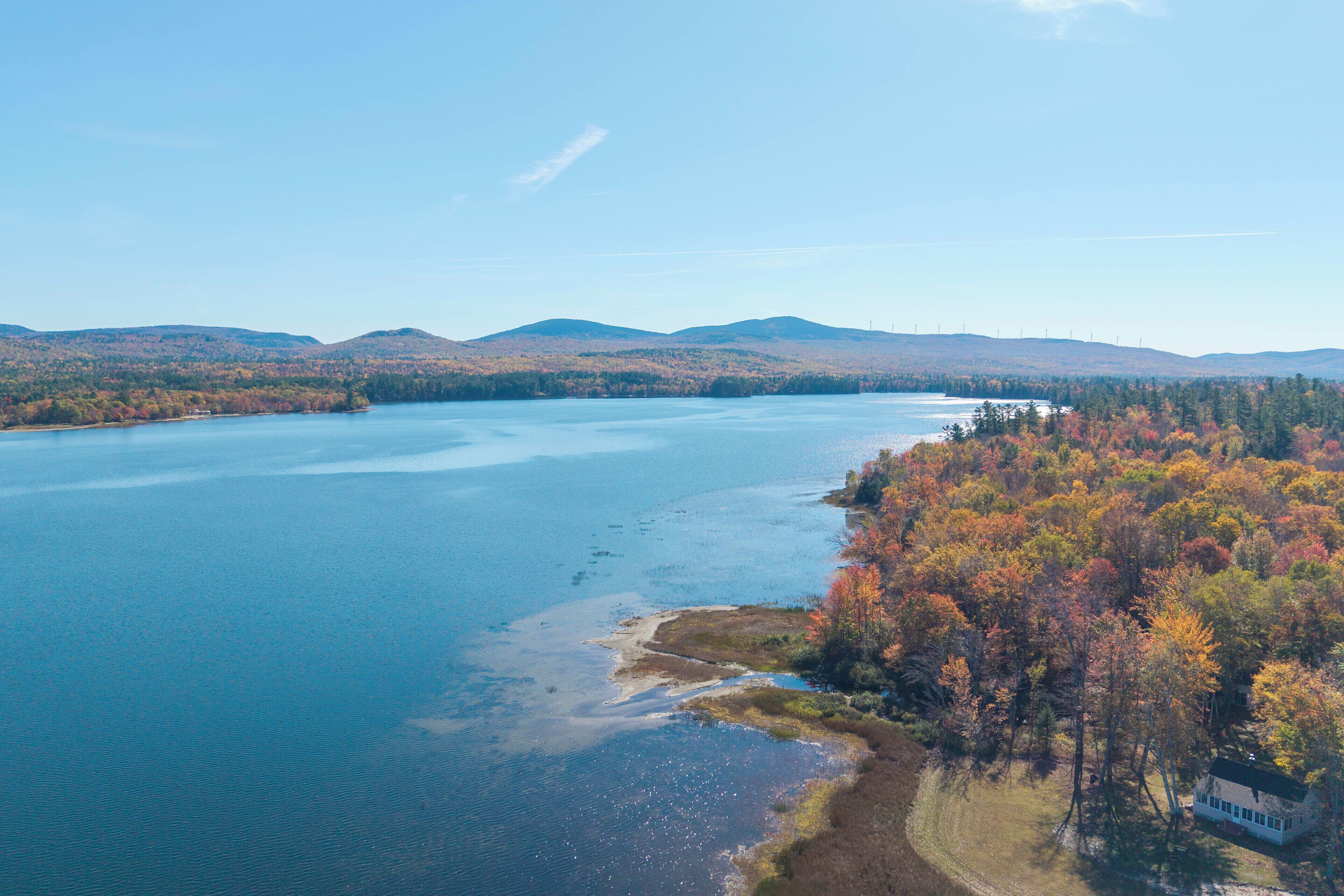 A large body of water surrounded by forested hills.