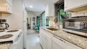 Eine moderne Küche mit weißen Schränken, einer Granitabdeckung und Edelstahlgeräten.