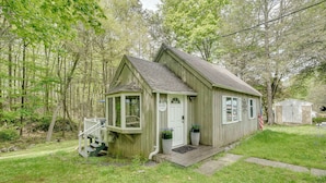 Eine kleine Holzhütte mit Veranda, einer kleinen Terrasse und einem Briefkasten.
