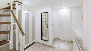 A hallway with a wooden staircase, white doors, and a large mirror. - FAMILY APARTMENT A/C FREE-BREAKFAST @OLD-TOWN (Budapest)
