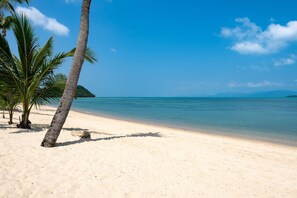 Na praia, espreguiçadeiras, toalhas de praia 