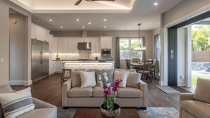 A modern kitchen with white cabinets, stainless steel appliances, and a central island. - Hale Ho'okipa: 2 Homes/2 Pools in Poipu-Sleeps 16 (Koloa)