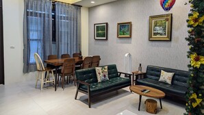 En moderne stue med spiseplads, med en sofa, et sofabord og et spisebord med stole.