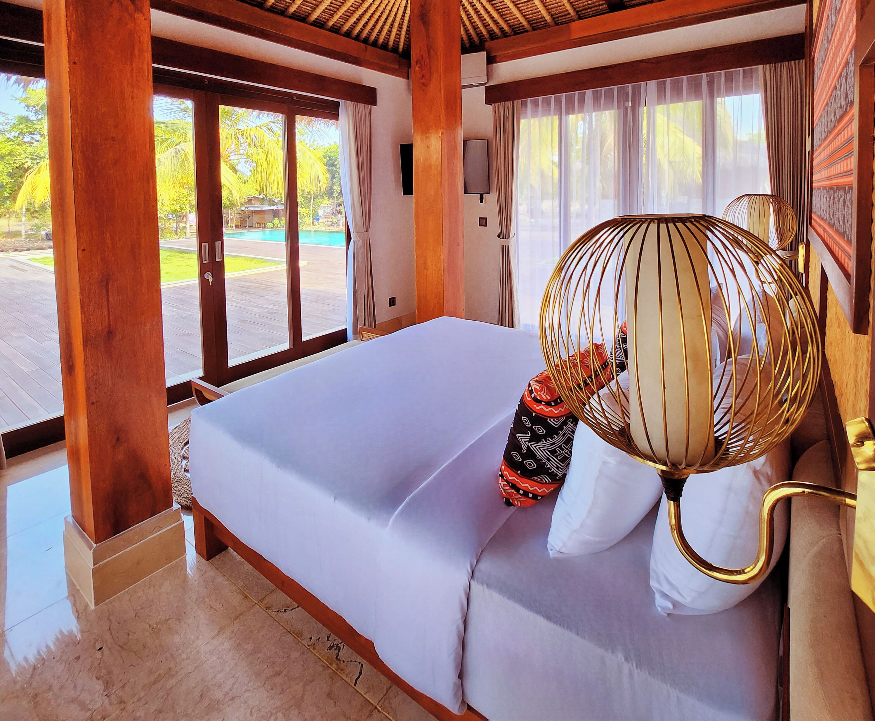 Una habitación con una cama, un ventanal y vista a una piscina.