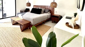 Une chambre moderne avec un lit, des tables de chevet, un ventilateur de plafond et une grande fenêtre.
