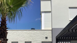 Un bâtiment moderne avec une façade en pierre, un palmier et une enseigne indiquant « Villa Diana ».