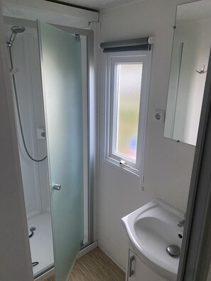 Chuveiro, secador de cabelo, sabonete, papel higiênico